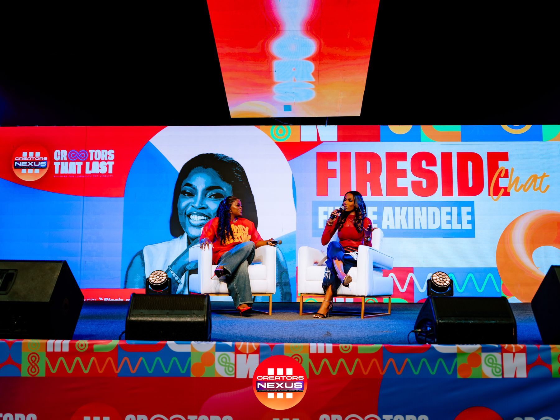 Two women in conversation on stage during a Fireside Chat.