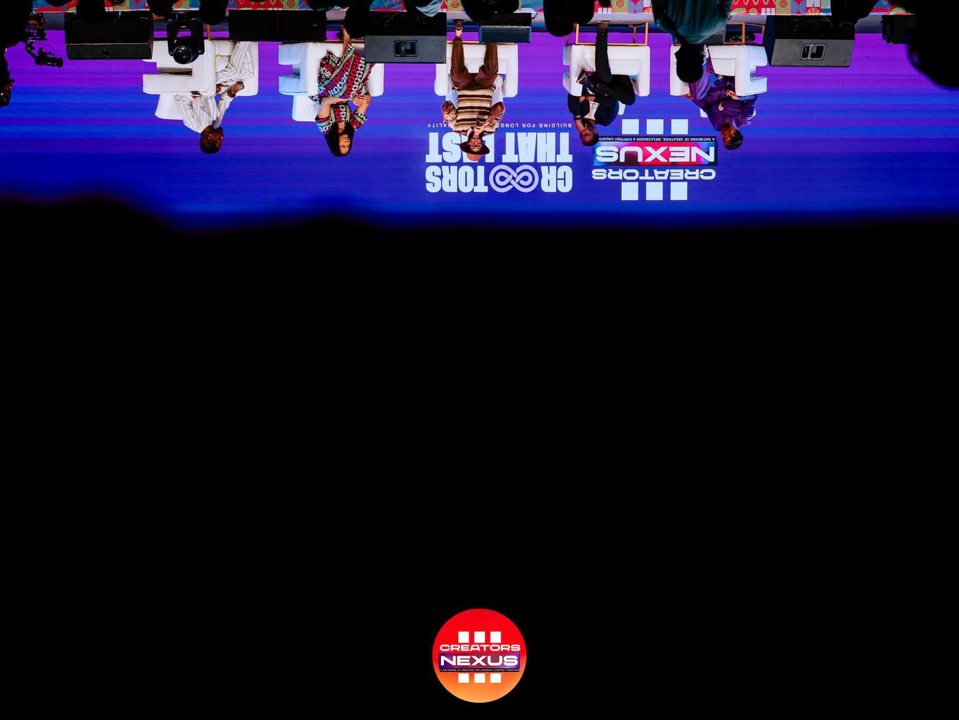 A speaker addressing the audience against the Creators Nexus backdrop.