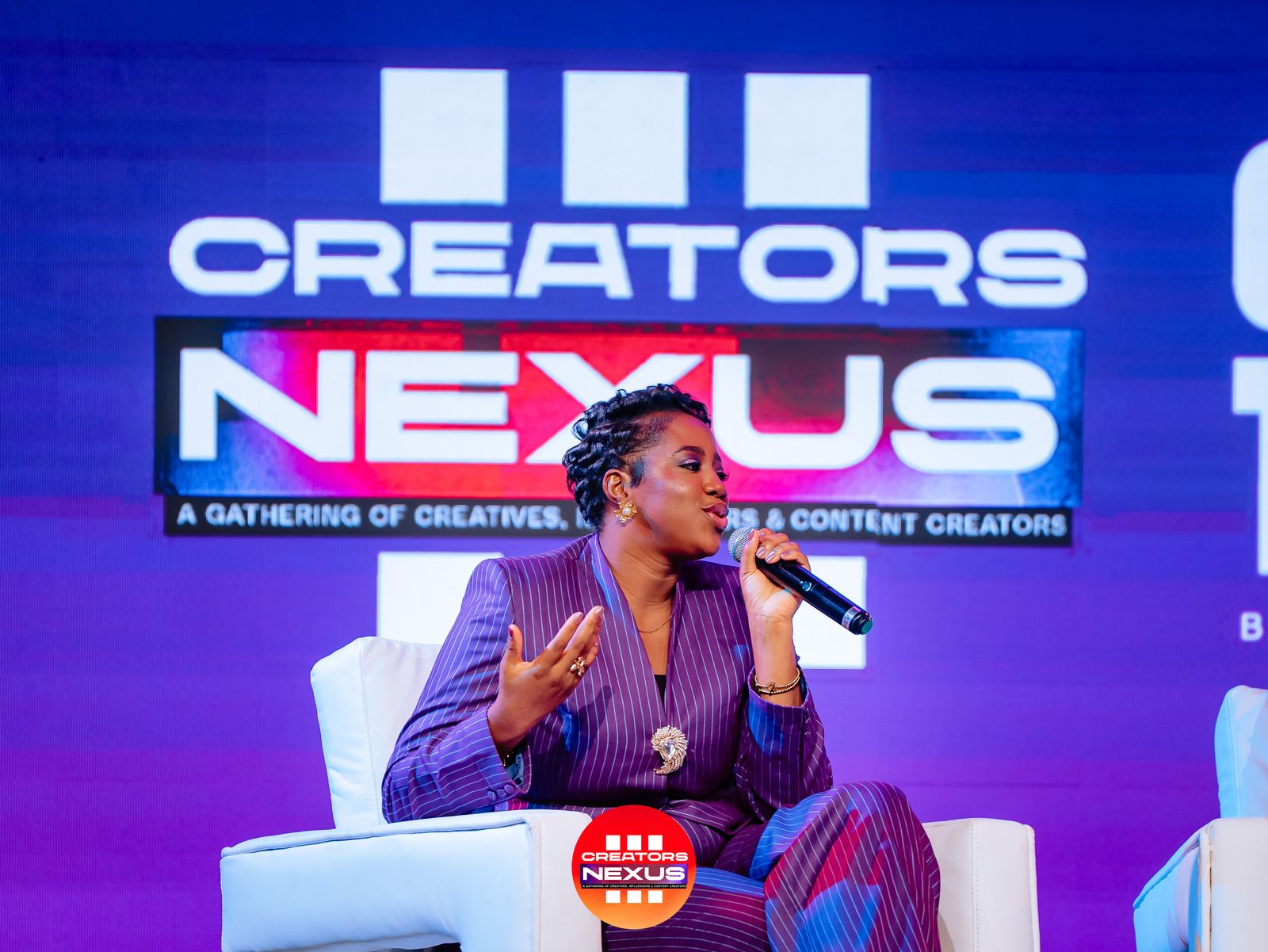 A guest speaking into a microphone during a Creators Nexus stage conversation.